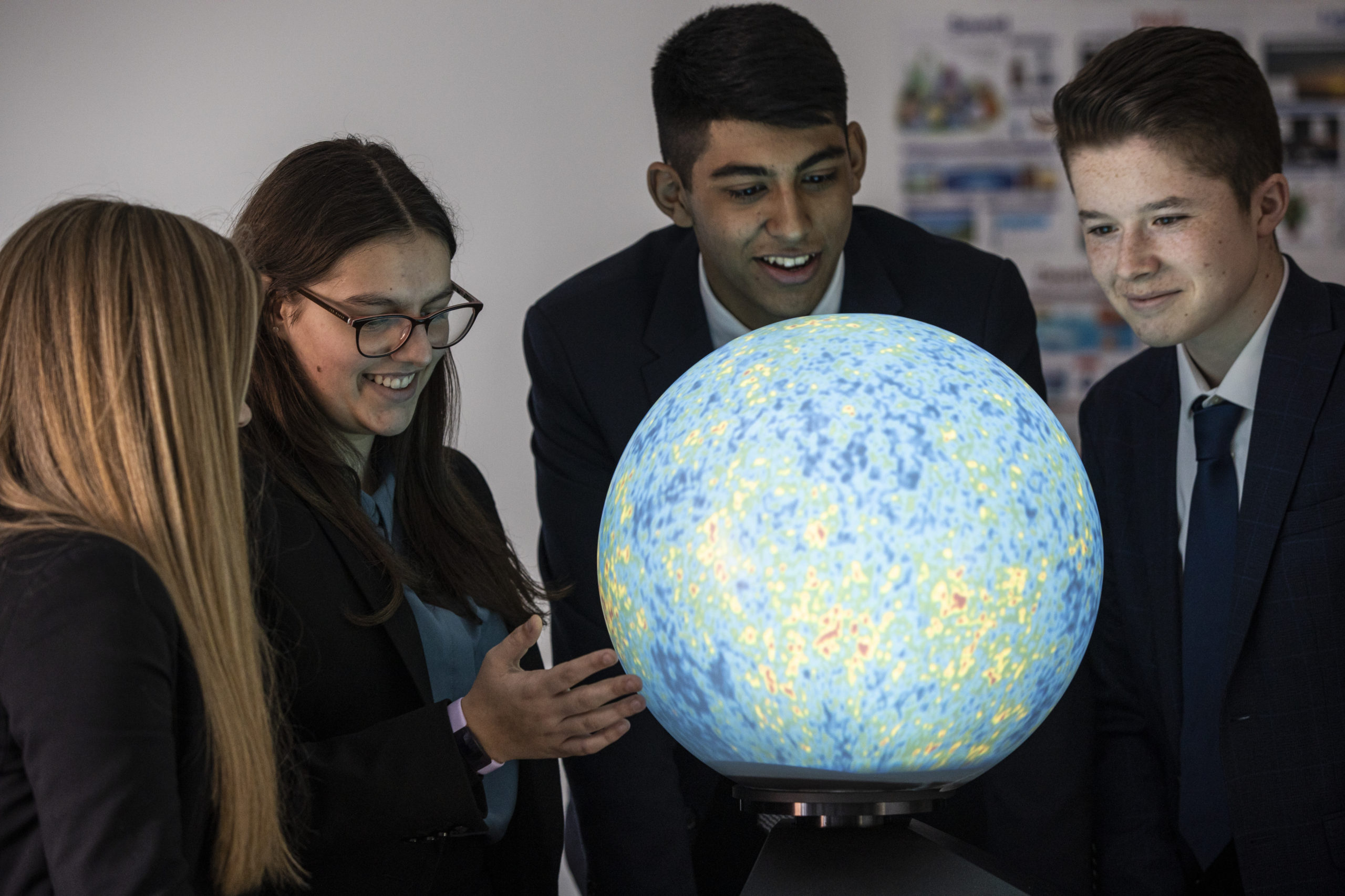 Students gathered around a physics model